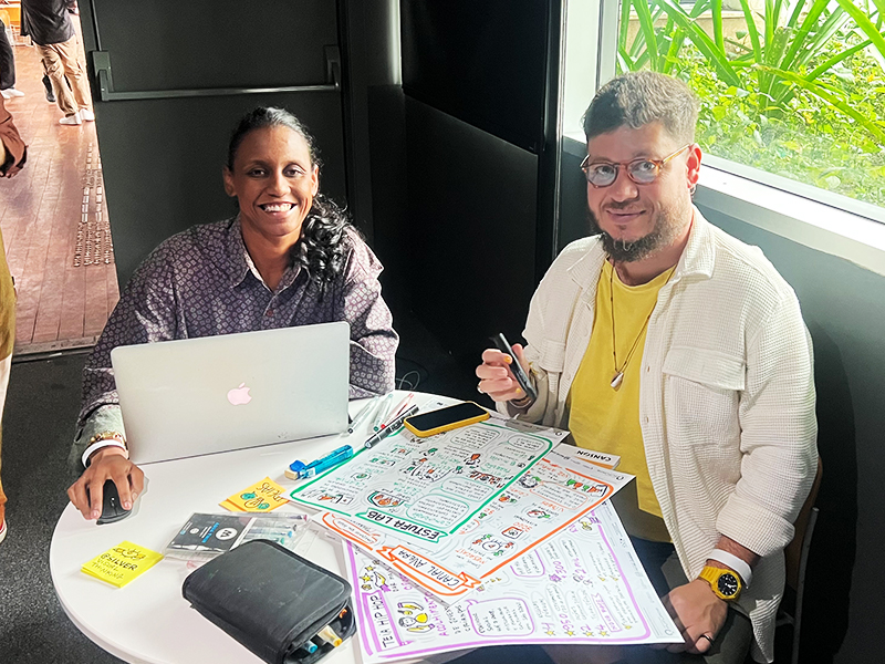 Equipa da Silver Visual Thinking sentada à mesa de produção com computador portátil, canetas e várias pranchas ilustradas como Estufa Lab e Canal Averá.  